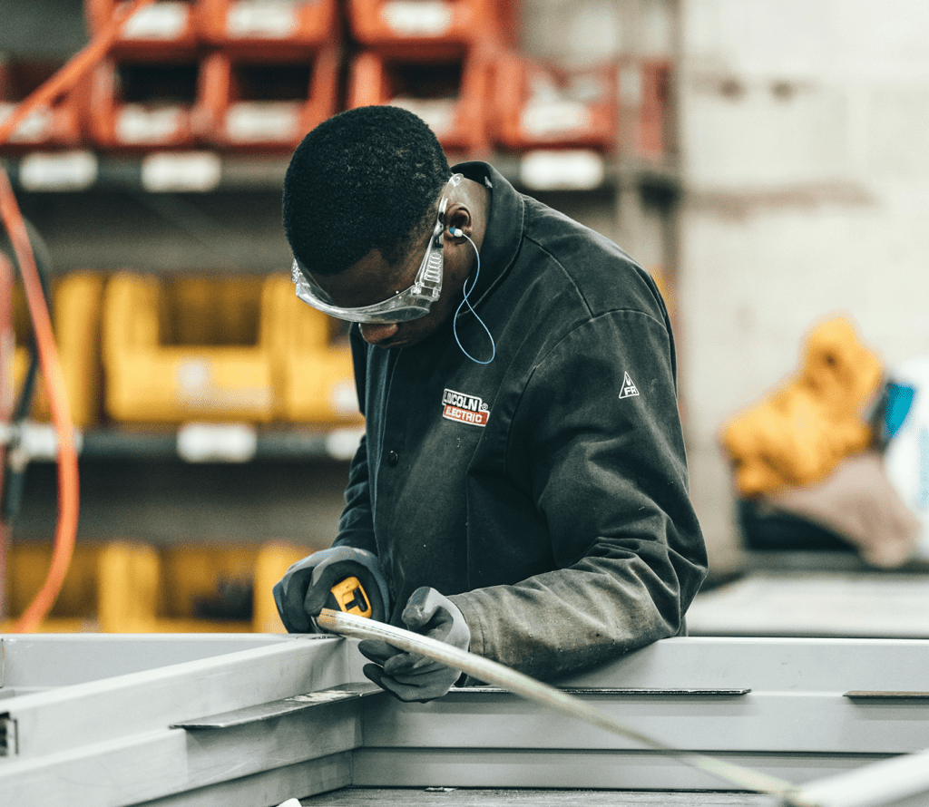 Man using a measuring tape in a construction workshop
